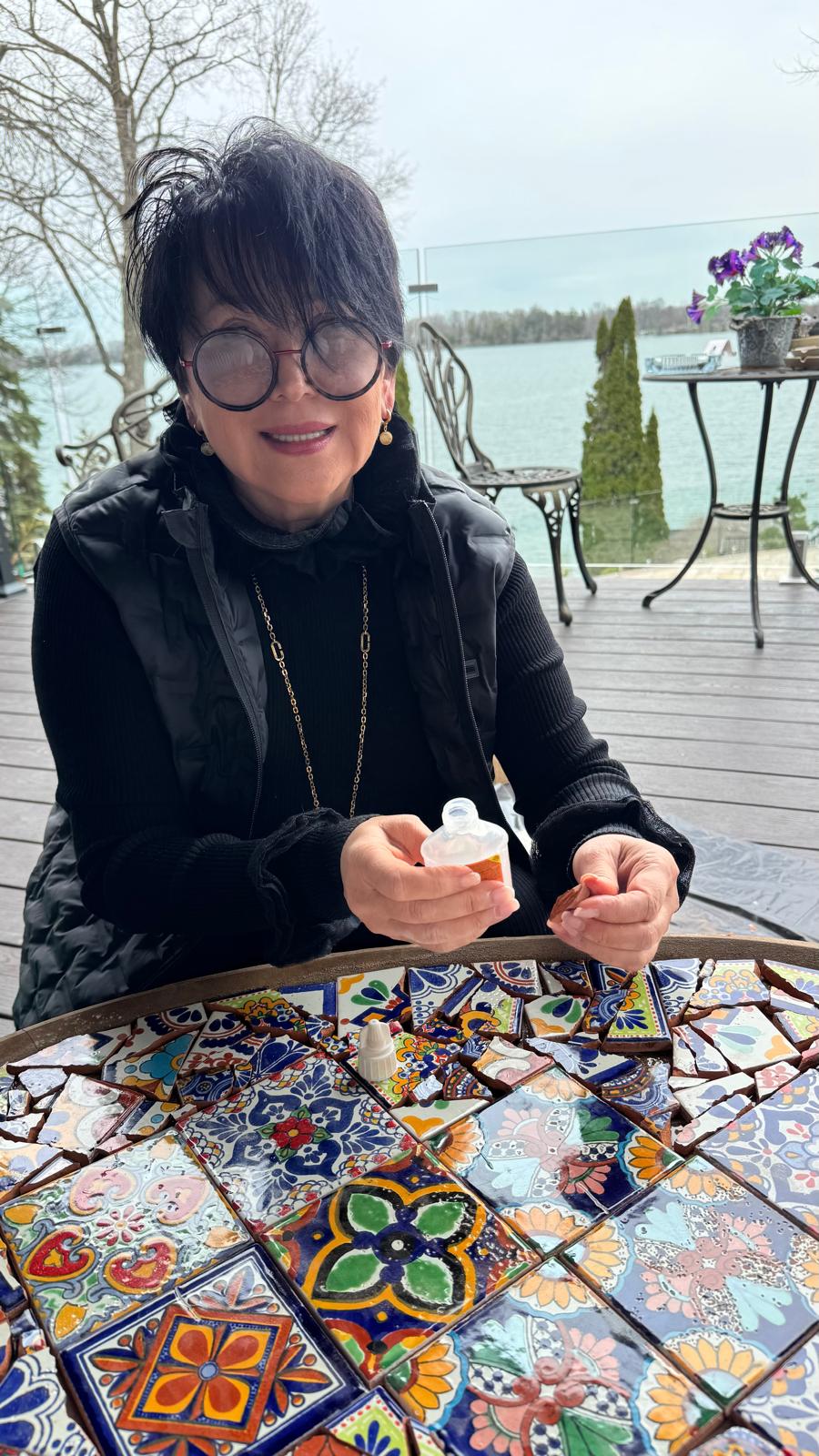 Nadia setting a glass piece into a mosaic lamp