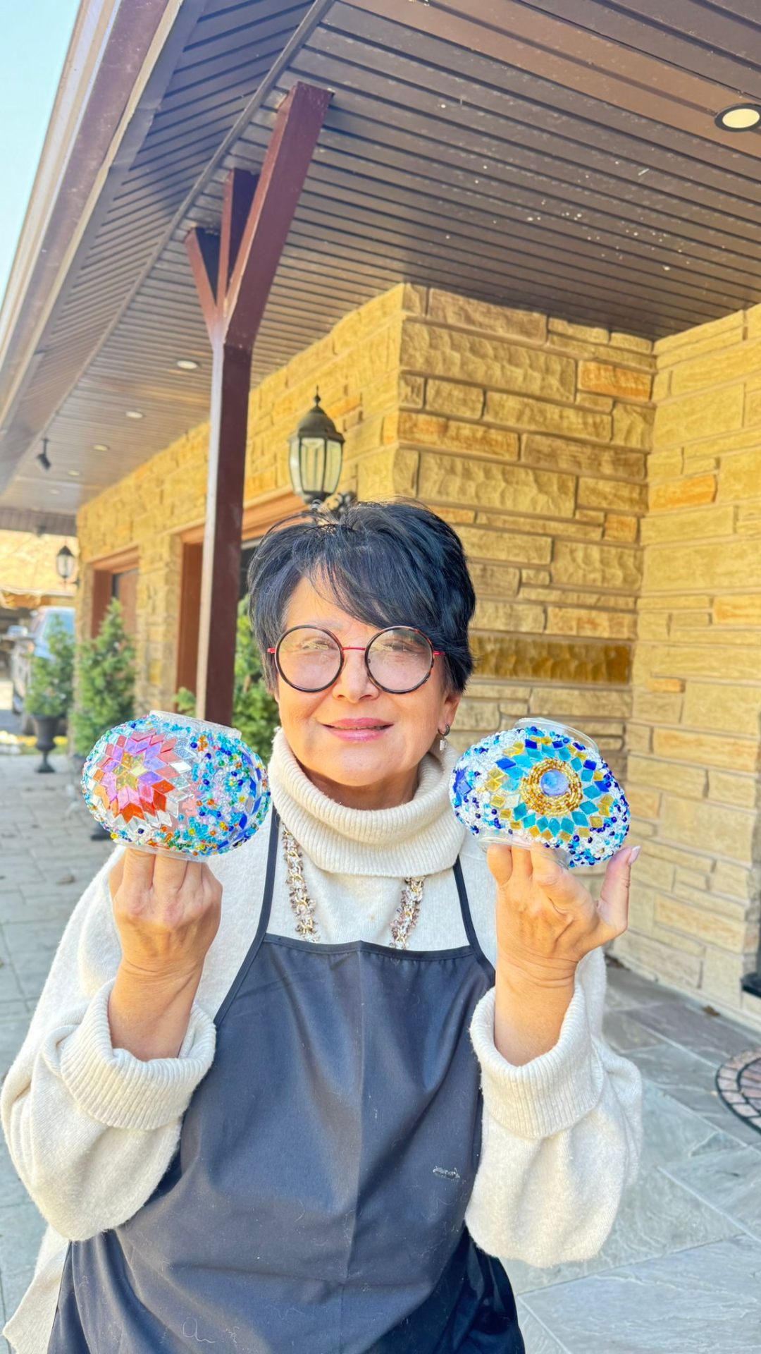 Nadia holding two handcrafted mosaic glass globes