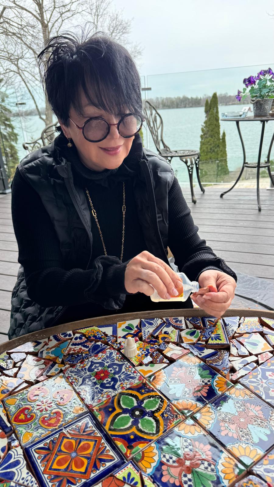 Nadia arranging cut glass tiles in her studio