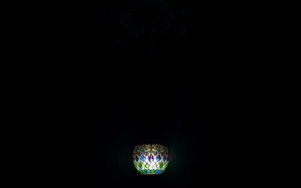 Single mosaic lamp creating dramatic lighting in a dark corner
