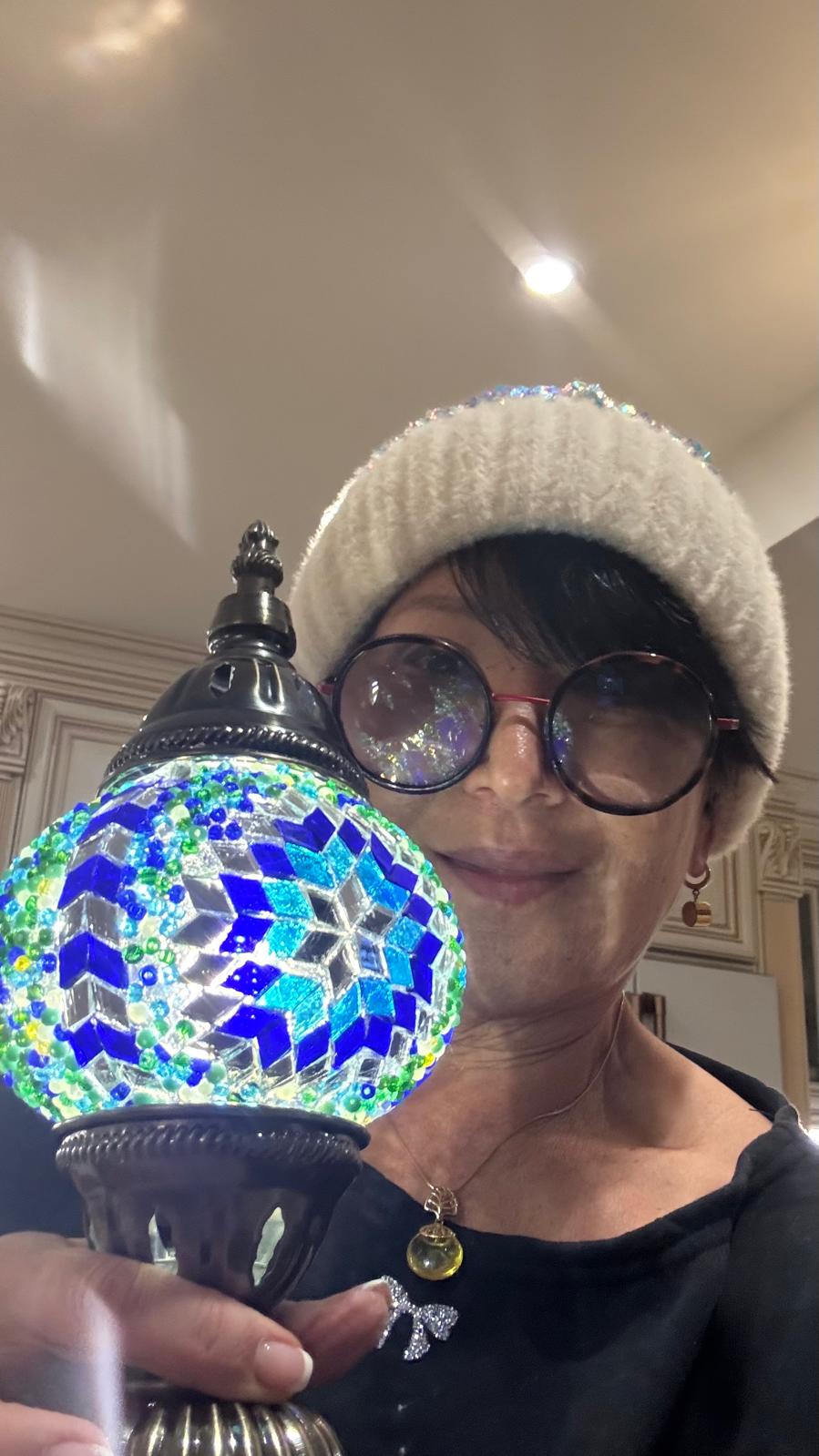 Nadia holding a glowing Sapphire Oasis lamp