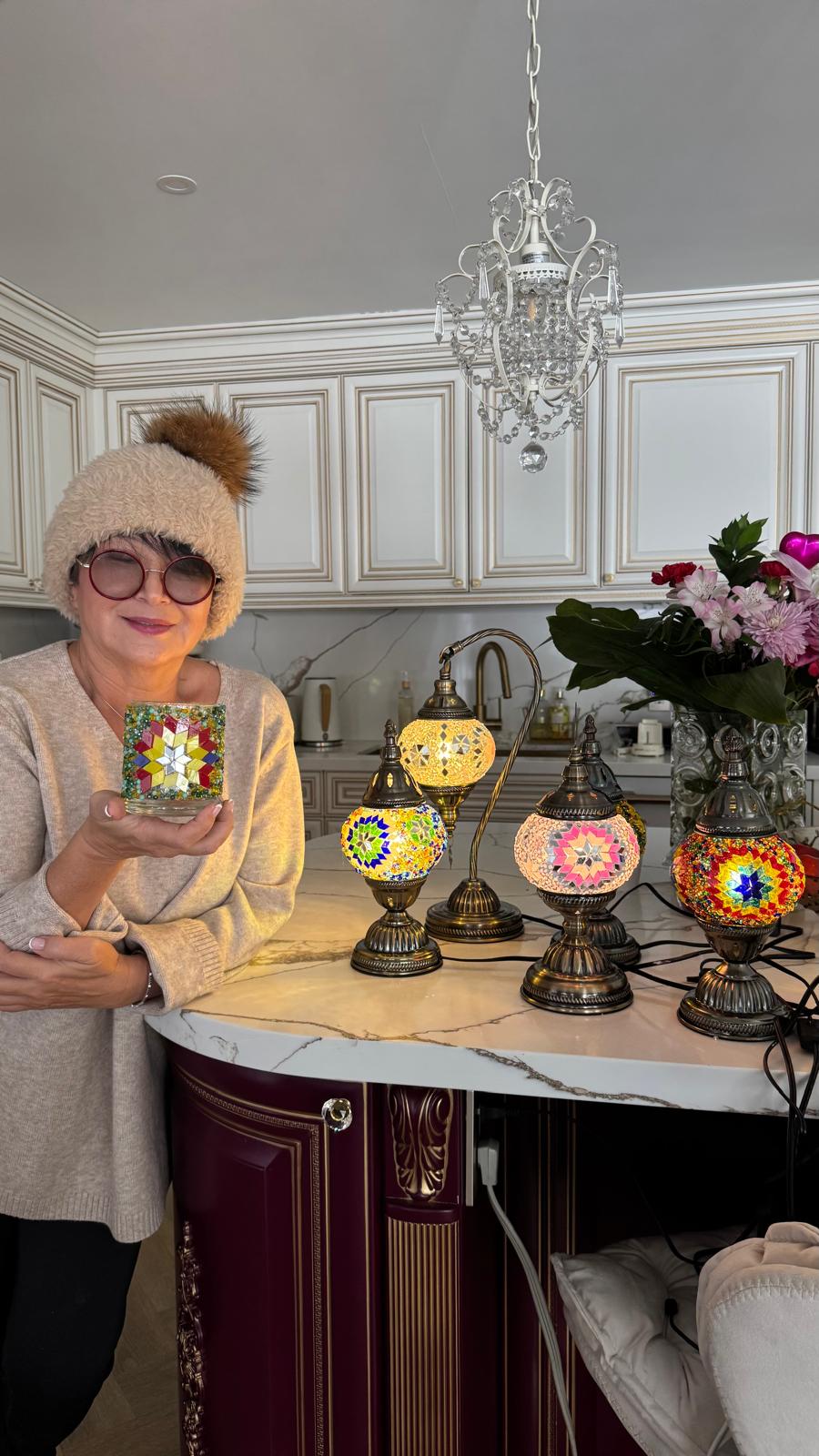 Nadia with her handcrafted mosaic lamp and candle holder collection
